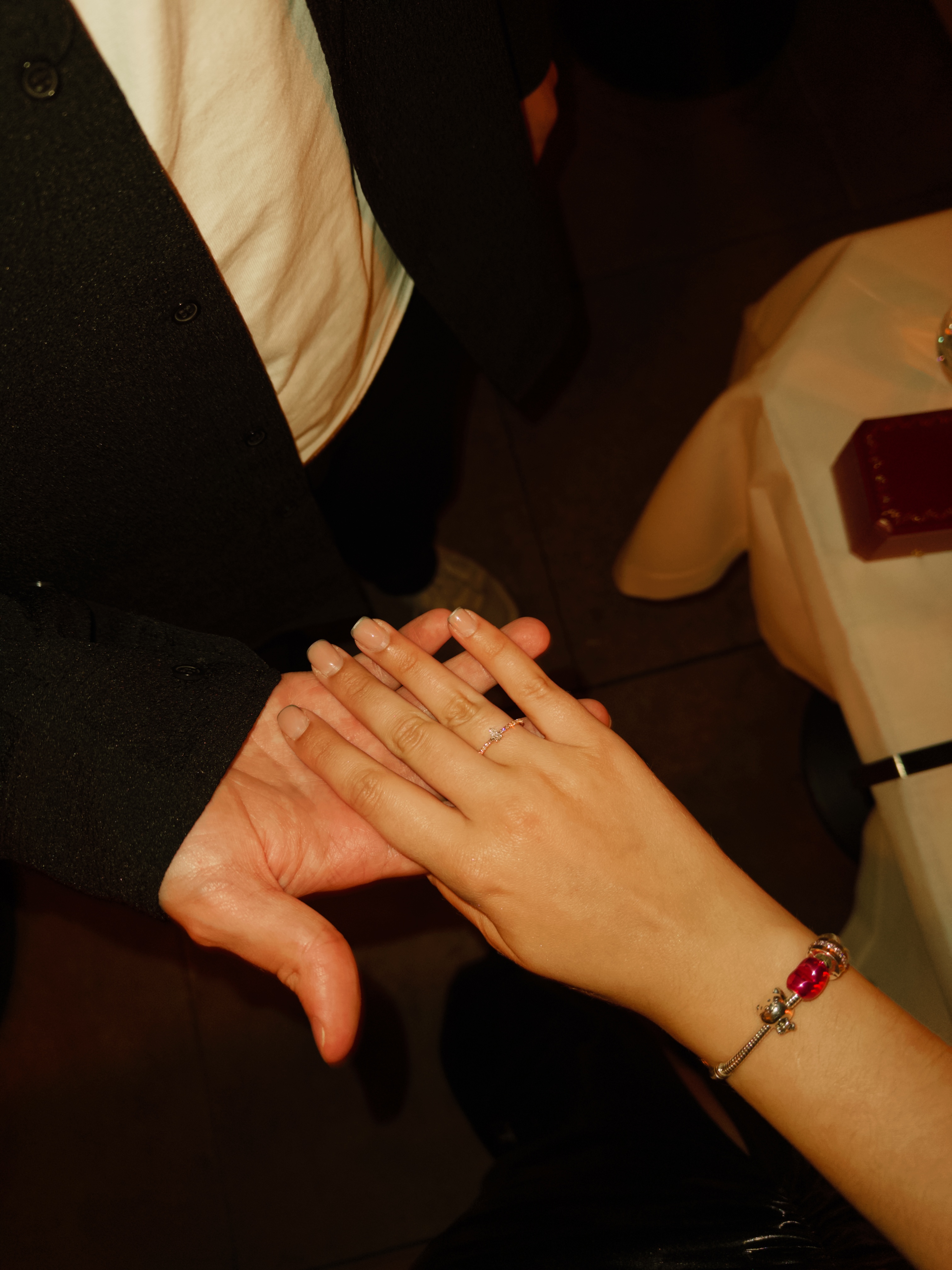 Руки молодожёнов с кольцом и браслетом